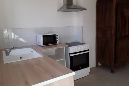 Coin cuisine avec un plan de travail et rangements.