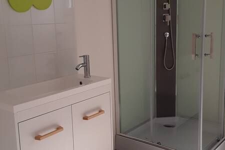 Salle de bain fonctionnelle avec rangement sous le lavabo et étagère supplémentaire.
